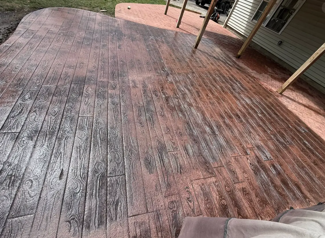 Stamped concrete patio finished to look like reddish-brown wood planks